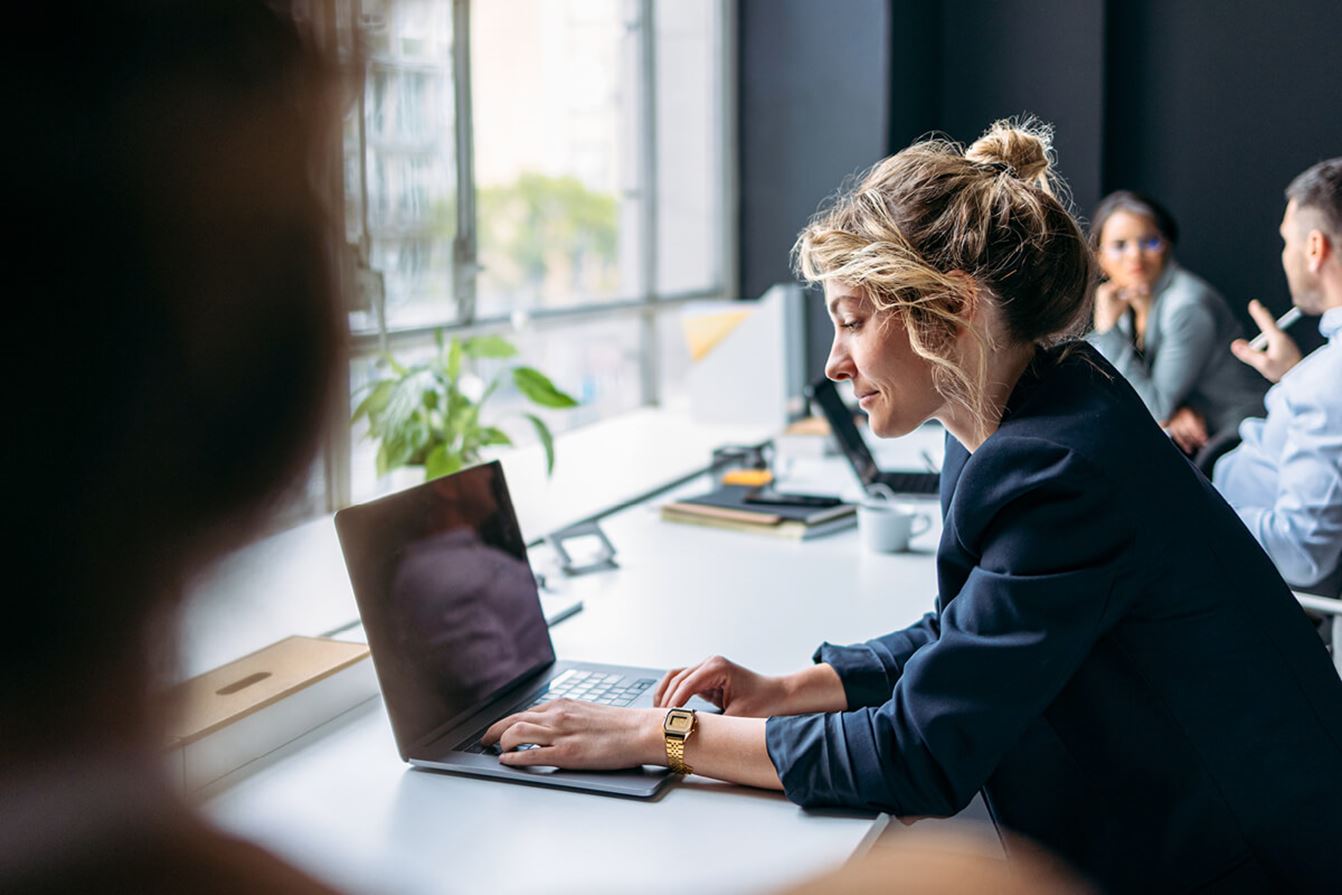 Person arbetar vid laptop på kontor.
