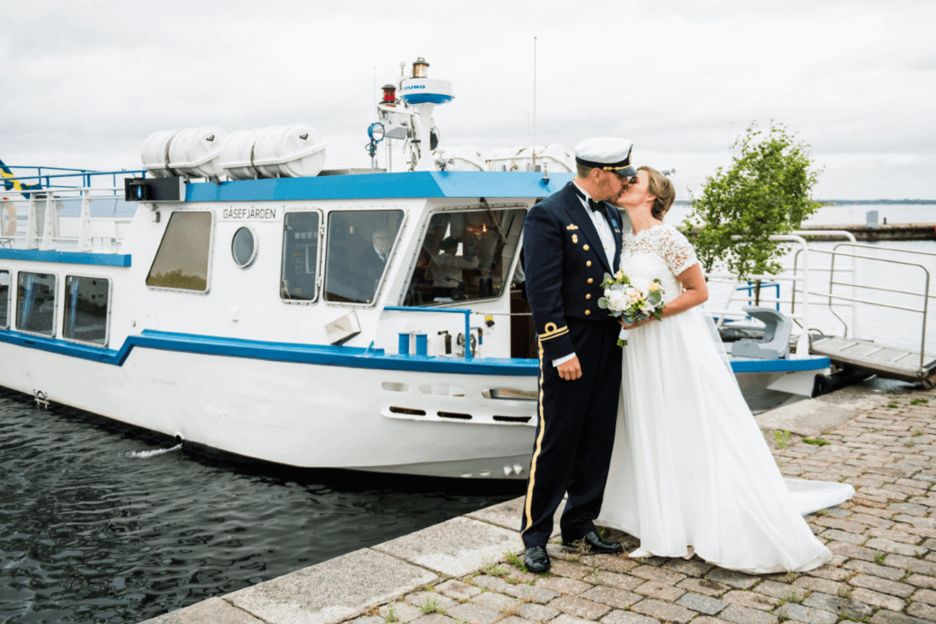 Bröllopspar framför en båt