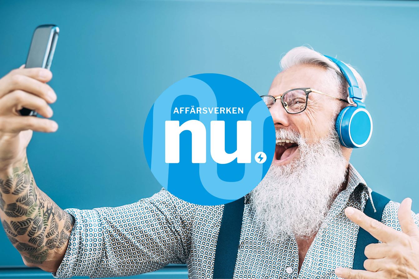 Äldre man med vitt skägg och glasögon bär blå hörlurar och tar en selfie med mobiltelefon. Han ler mot kameran mot en blå bakgrund, med en illustration av texten ”Affärsverken nu” i förgrunden.